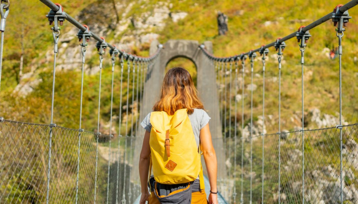 A young woman crossing the Holtzarte suspension bridge, Larrau. In the forest or jungle of Irati, north of Navarra in Spain and the Pyrenees-Atlantiques of France